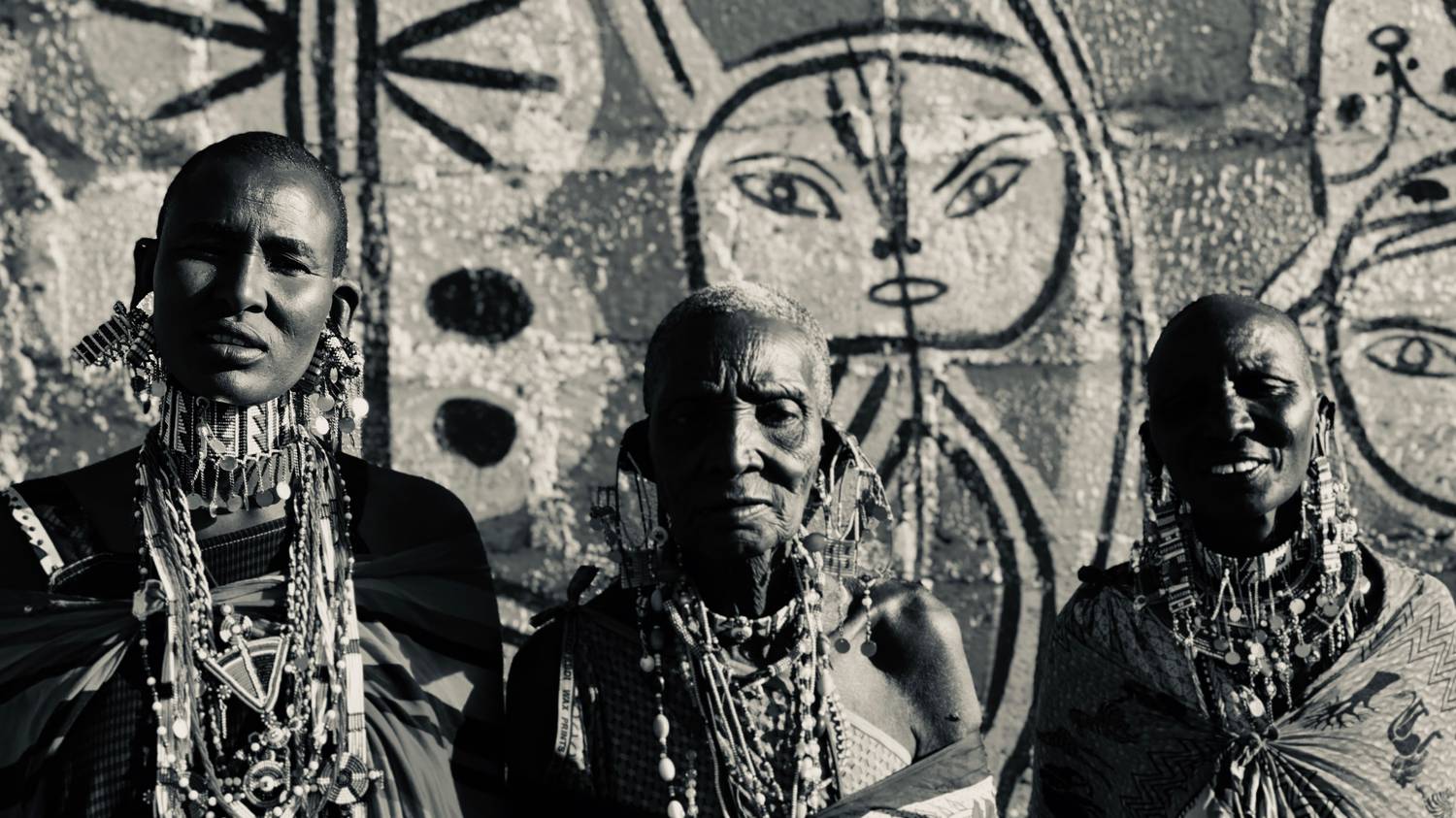 Maasai women before a painted wall in Momella