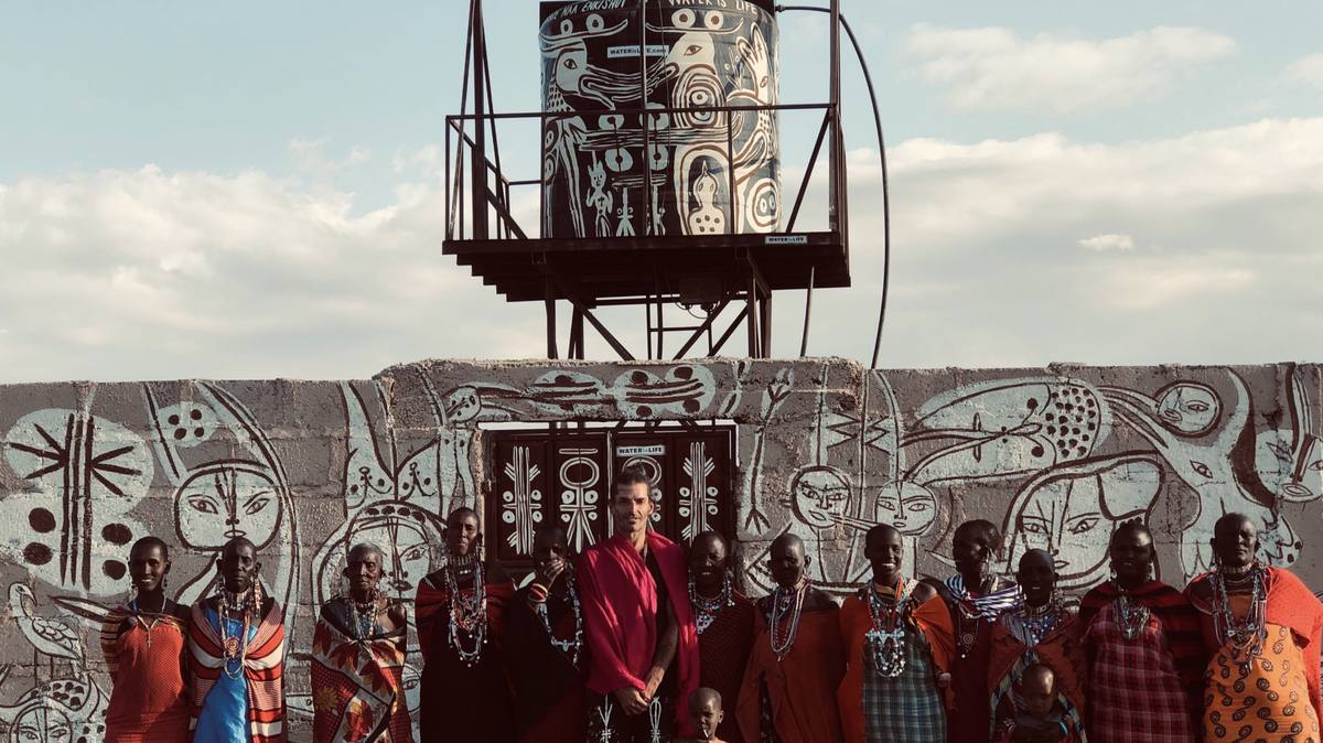 Maasai women in front of a painted water tank in Momella